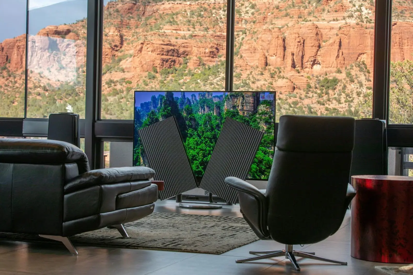 The listening seat view — Beovision Harmony and Beolab 50 speakers against the red rock windows