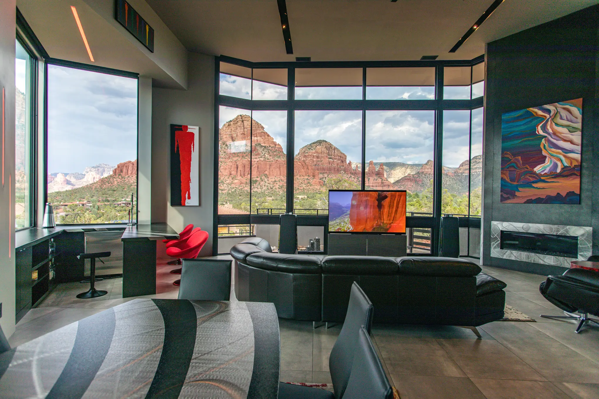 Bang & Olufsen Beovision Harmony open on a canyon image in a Sedona living room, red rocks through the corner windows and a fireplace with abstract art — Watt Integration project home