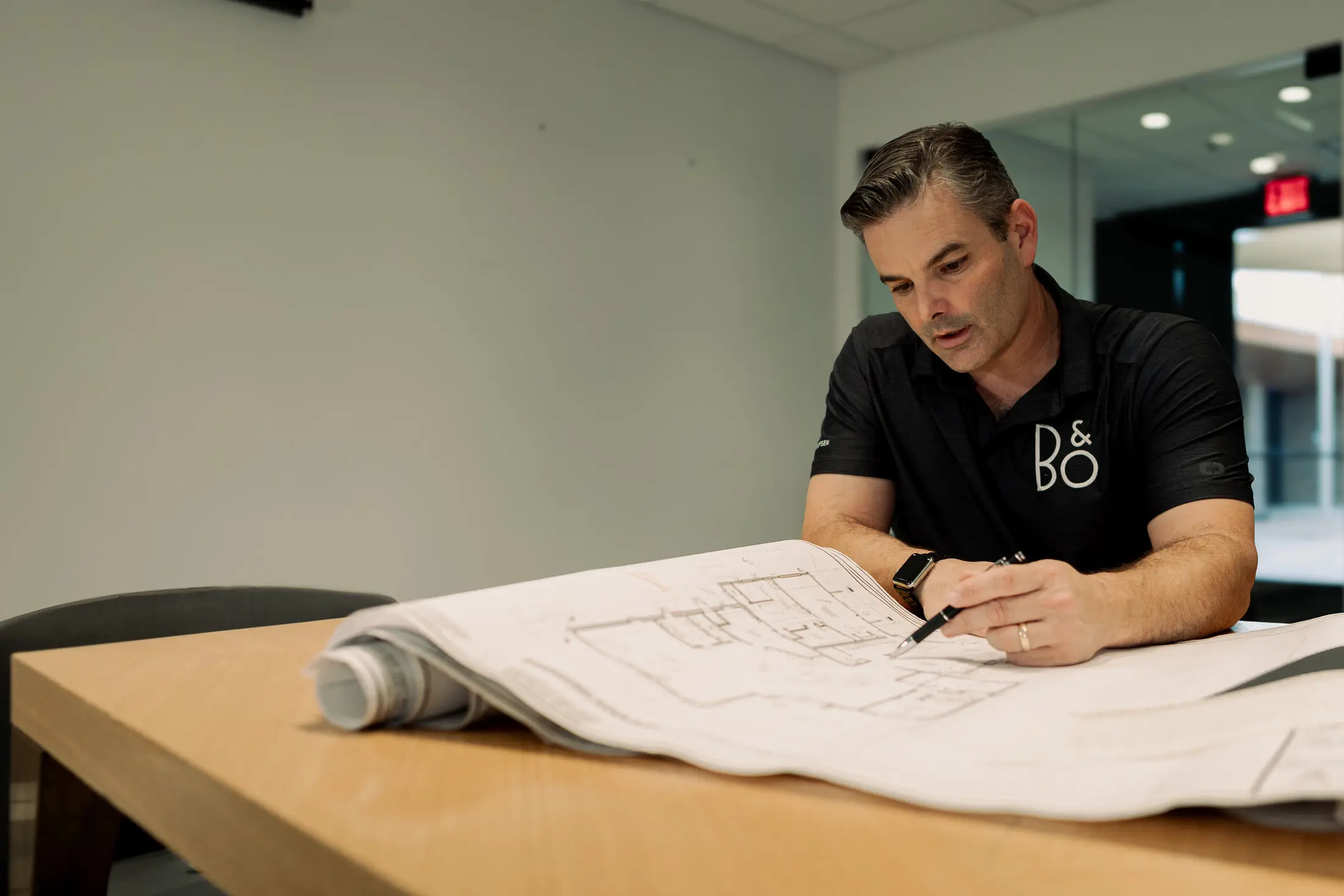 Bryan Watt marking up floor plans on a work table during the design and engineering stage of a Watt Integration project
