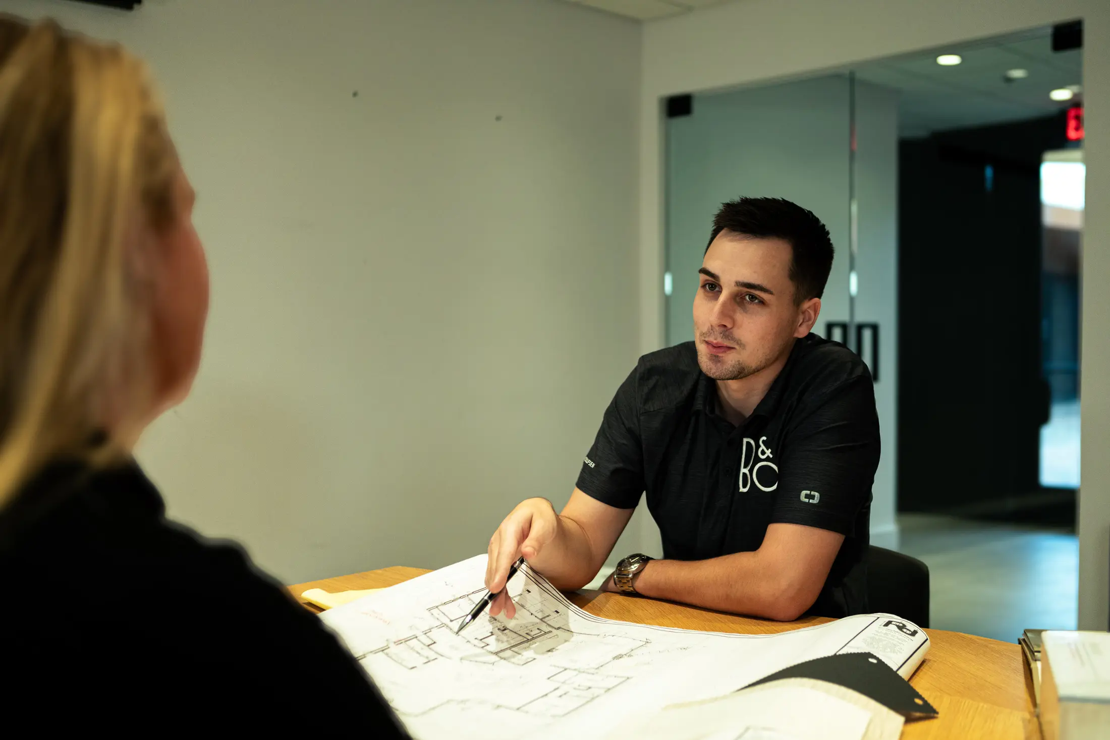 A Watt Integration team member reviews floor plans with a client at the Scottsdale showroom