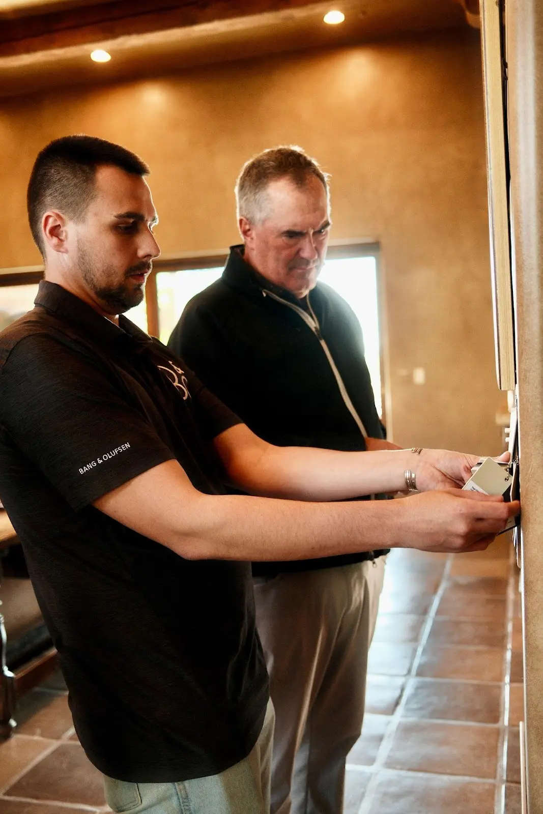 A Watt Integration technician walks John through the new wall keypad after the installation